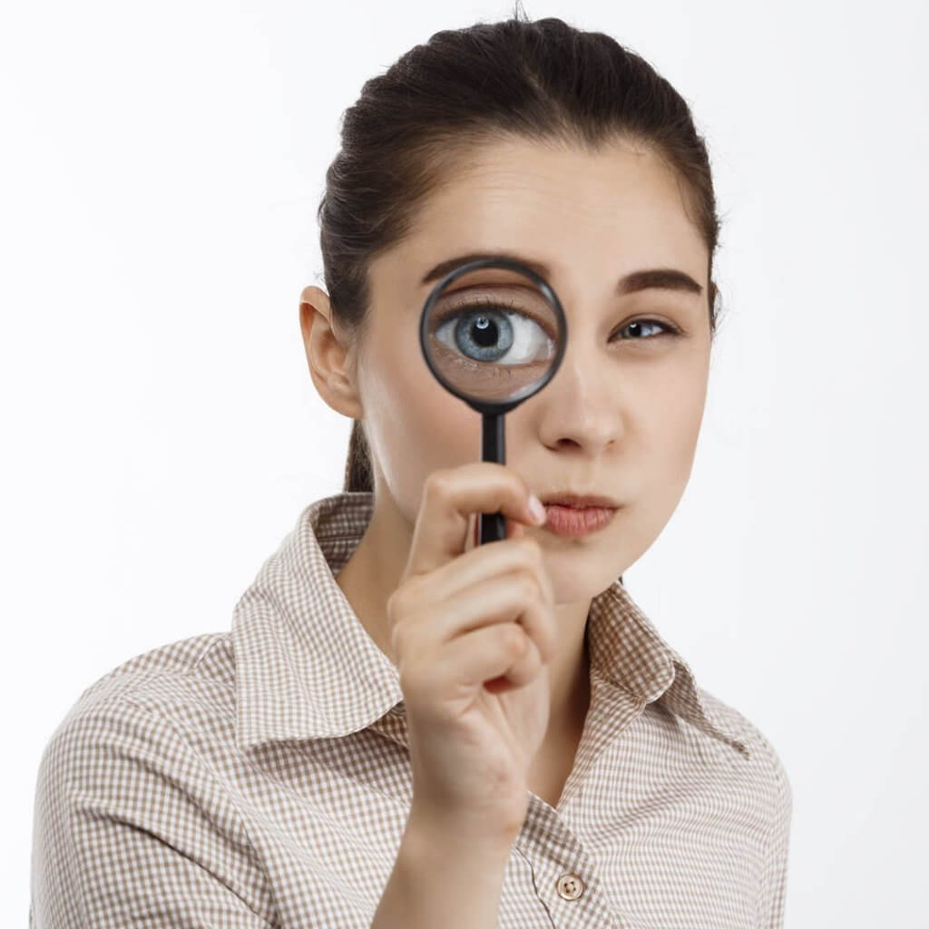 Mujer joven mirando por lupa
