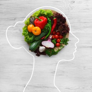 Contorno de mujer dibujado, con ensalada de verduras en su cerebro